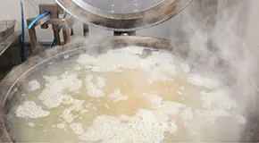 スライスしたごと芋を大釜で煮ていきます。